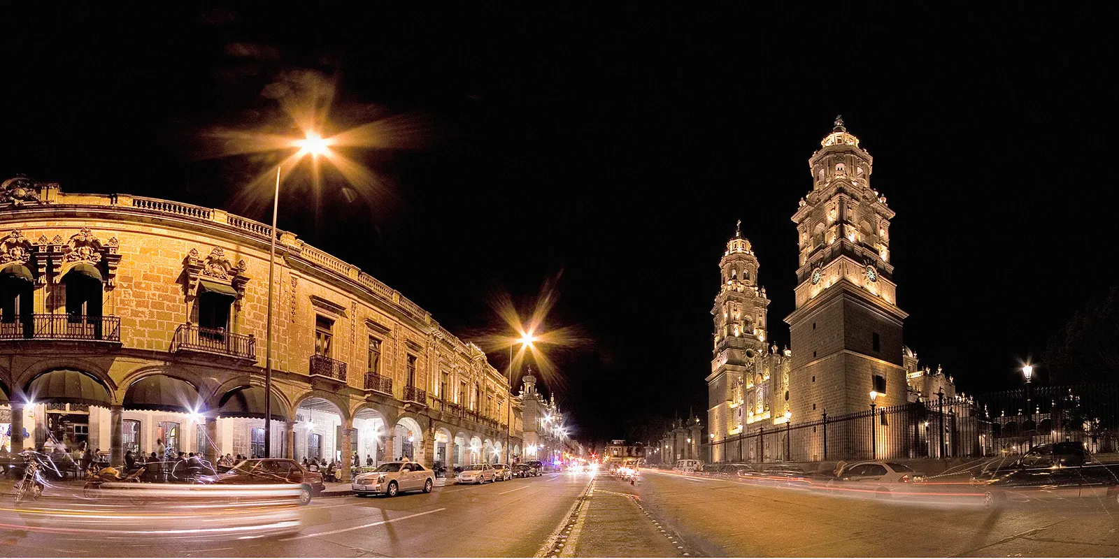 La Catedral de Morelia iluminada de noche sobre la avenida Madero, con sus portales